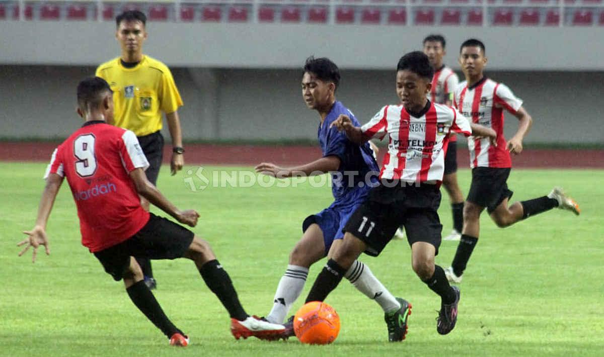 Aksi pemain Kalimantan Barat (Biru) dihadang dua pemain Sumatera Barat pada babak final Piala Soeratin U-15 2019-2020 di Stadion Manahan Solo, Sabtu (29/02/20).