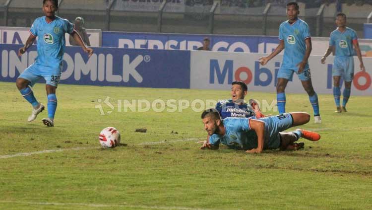 Dalam upaya mengejar bola, pemain Persib Bandung dan Persela Lamongan sempat harus terjatuh.