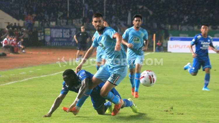 Langkah Geoffrey Castillion sempat terhadang pemain Persela Lamongan saat berusaha mencetak gol bagi Persib Bandung di pekan pertama Liga 1 2020.