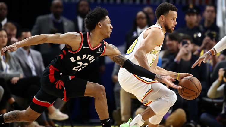 Bintang basket NBA dari Golden State Warriors, Stephen Curry (kanan) kembali bermain pasca cedera, pergerakannya dijaga oleh pemain Toronto Raptors, Patrick McCaw.