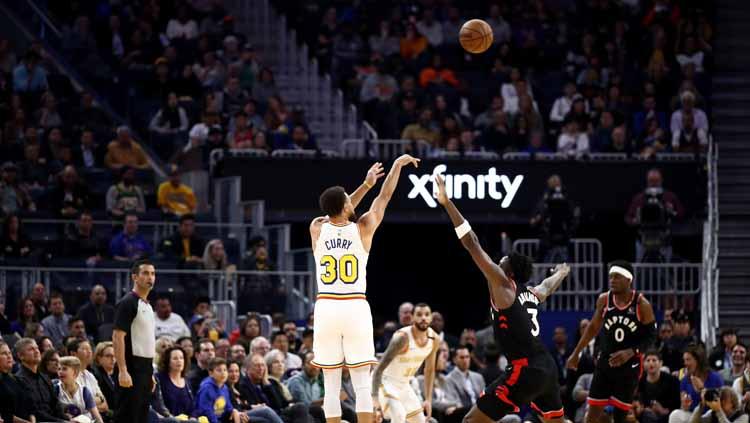 Aksi three points shots dari pemain megabintang Golden State Warriors, Stephen Curry saat melawan Toronto Raptors.