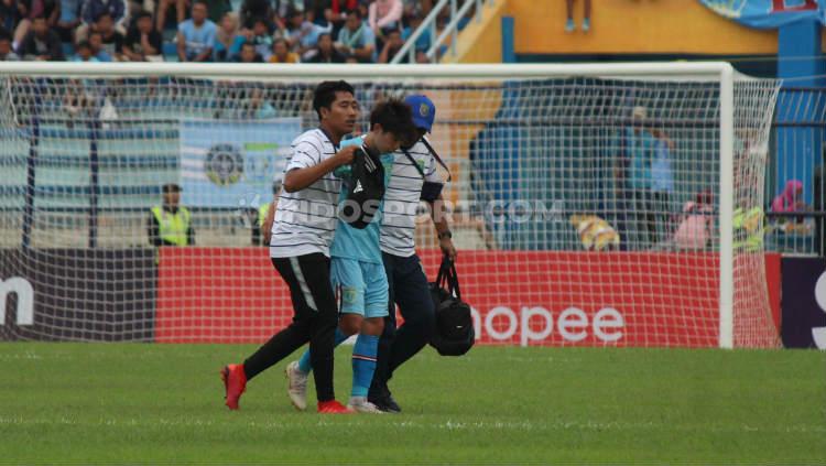 Pemain Persela Lamongan Shunsuke Nakamura muntah-muntah di tengah lapangan dan wasit meminta untuk langsung diganti. Copyright: Fitra Herdian Ariestianto/INDOSPORT