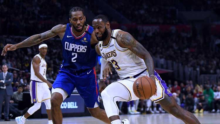 Pemain bintang LA Clippers, Kawhi Leonard (kiri) berduel dengan bintang LA Lakers, LeBron James. Copyright: Harry How/GettyImages