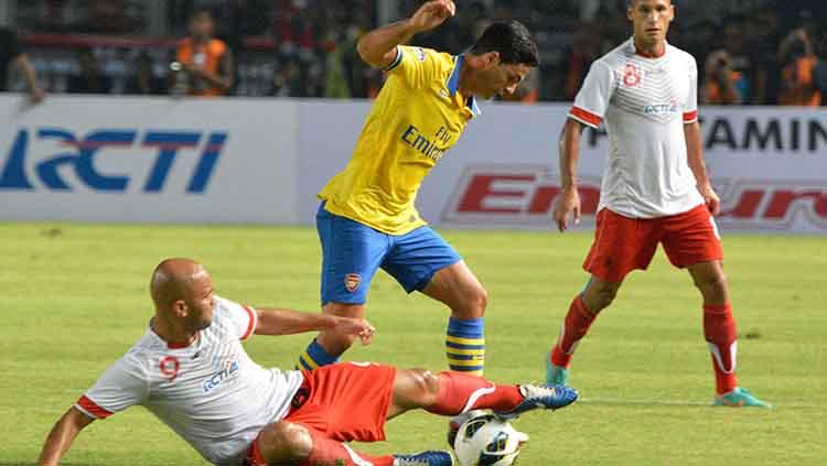 Mikel Arteta menghindari tekel dari Sergio van Dijk dalam laga eksebisi Arsenal vs Indonesia All-Stars. Copyright: Robertus Pudyanto/Getty Images