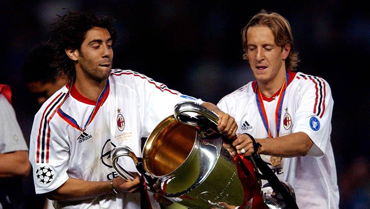 Dua mantan pemain AC Milan Manuel Rui Costa (kiri) dan Massimo Ambrosini (kanan) saat mengangkat gelar Liga Champions. Copyright: Neal Simpson/EMPICS via Getty Images