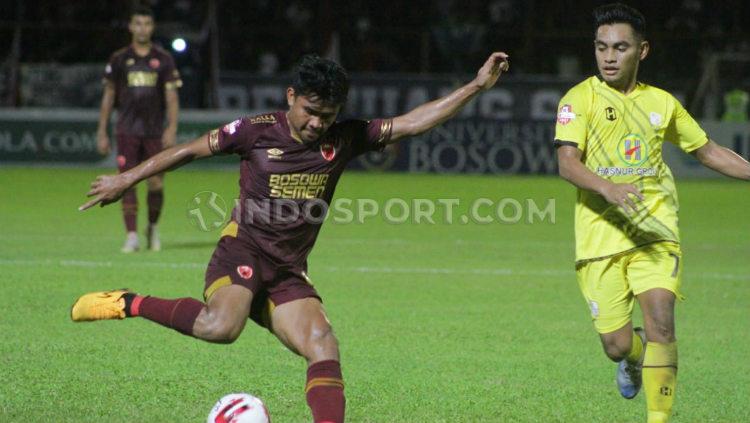 Bek kanan PSM Makassar, Asnawi Mangkualam (merah marun), mencoba melewati hadangan pemain Barito Putera, Ambrizal Umanailo (kuning). - INDOSPORT