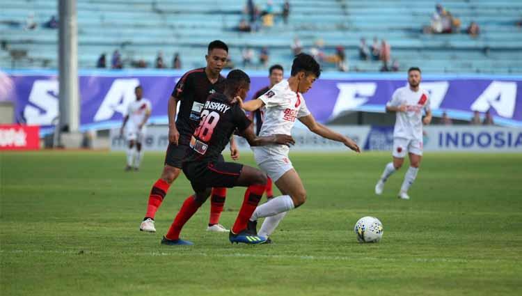 Pemain klub Liga 1 PSM Makassar, Aji Kurniawan (putih), mencoba melewati hadangan pemain Persipura Jayapura. Copyright: Official PSM Makassar