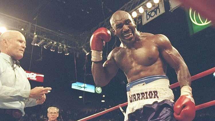 Evander Holyfield menunjuk ke telinganya yang berdarah setelah Tyson menggigitnya (28/06/1997). - INDOSPORT
