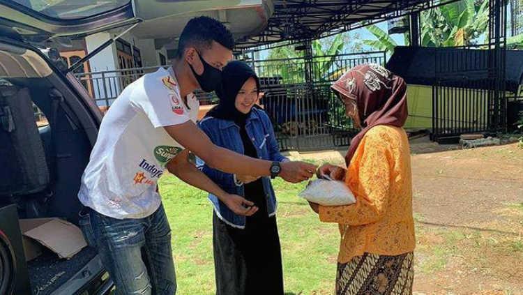 Bek Badak Lampung, Ikhfanul Alam (kiri) saat membagikan bantuan dari hasil lelang Jersey, kepada sejumlah masyarakat di kabupaten Malang. - INDOSPORT