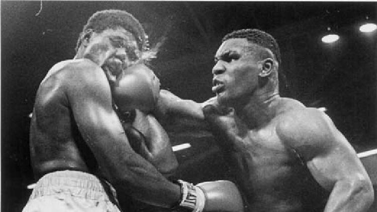 James Tillis (kiri) menerima pukulan keras dari Mike Tyson dalam laga tinju kelas berat tahun 1986.