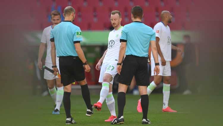 Maximilian Arnold, pemain Vfl Wolfsburg beradu sepatu dengan asisten wasit setelah laga Bundesliga antara FC Augsburg vs VFL Wolfsburg, Sabtu (16/05/20).