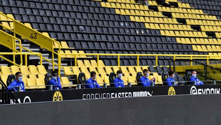 Para pemain cadangan FC Schalke 04 duduk berjauhan di bench dalam laga Bundesliga melawan Borussia Dortmund, Sabtu (16/05/20).