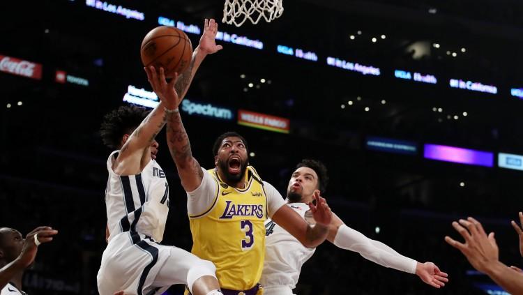 Bintang LA Lakers, Anthony Davis (tengah) saat dikepung oleh dua pemain Memphis Grizzlies dalam pertandingan NBA pada akhir Februari 2020 lalu. - INDOSPORT