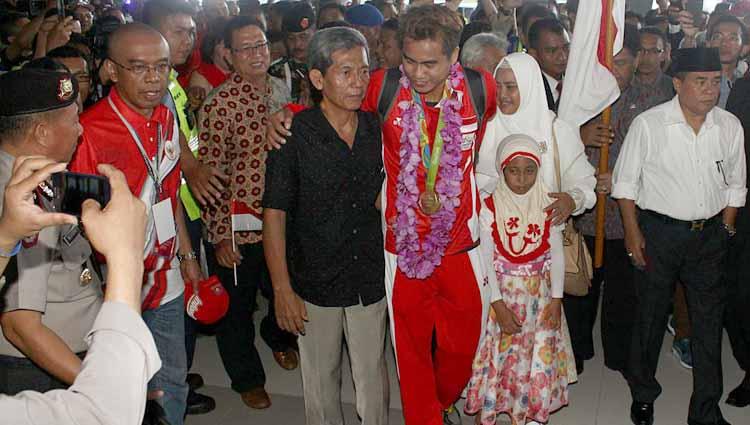 Pemain bulutangkis Indonesia Tantowi Ahmad bersama kedua orangtua usai tiba di Bandara Sukarno Hatta Tangerang, Indonesia.