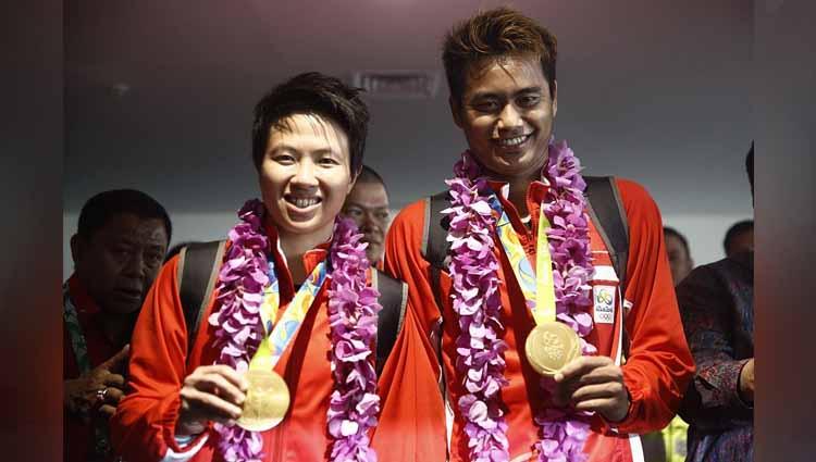 Pemain bulutangkis Indonesia Liliyana Natsir (kiri) dan Tantowi Ahmad (kanan) berpose dengan medali mereka setelah tiba di Bandara Sukarno Hatta Tangerang, Indonesia.