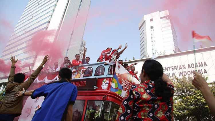 Pemenang medali emas Olimpiade Indonesia Tontowi Ahmad dan Liliyana Natsir mendapat sambutan oleh ratusan penggemar yang mengibarkan bendera Merah Putih.