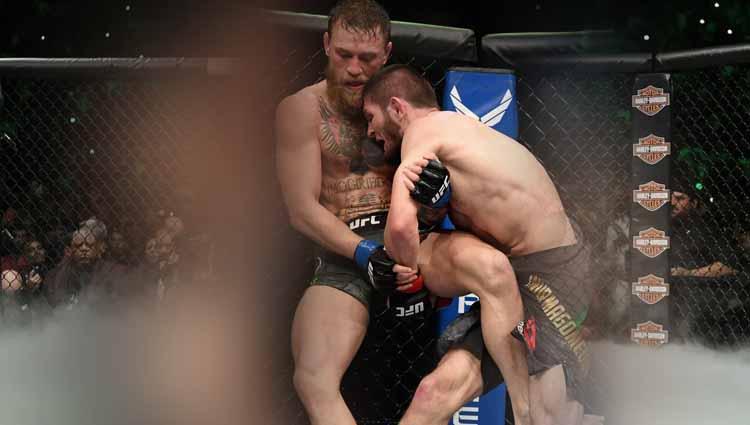 Nurmagomedov membanting dengan jepitan kaki McGregor di sudut.