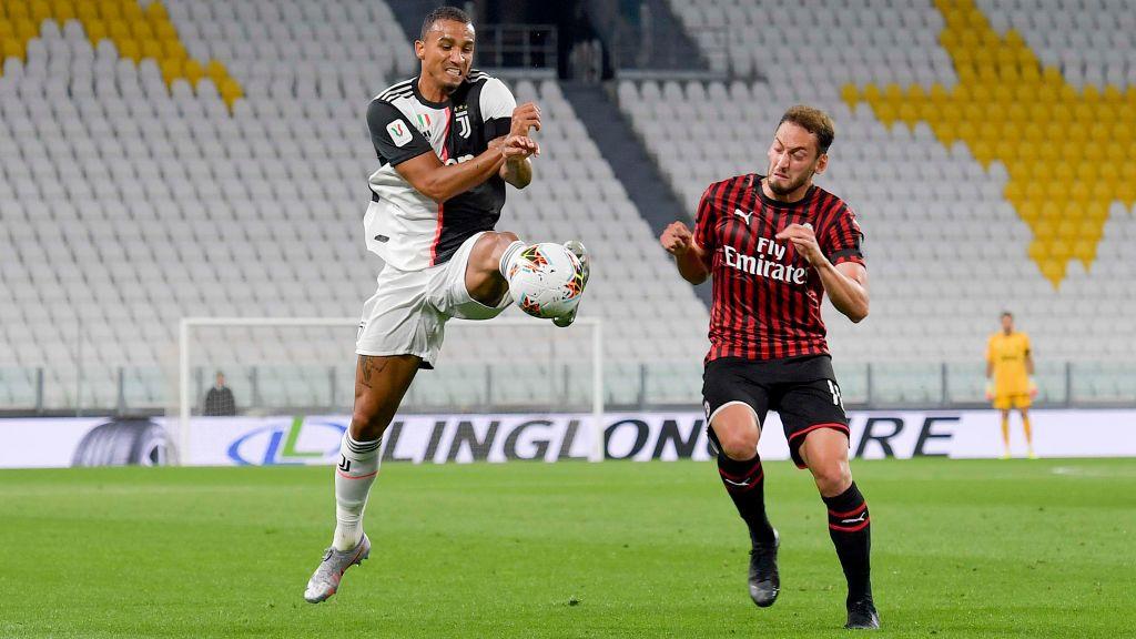Hakan Calhanoglu (kanan) berduel dengan Danilo di laga semifinal Coppa Italia antara Juventus vs AC Milan