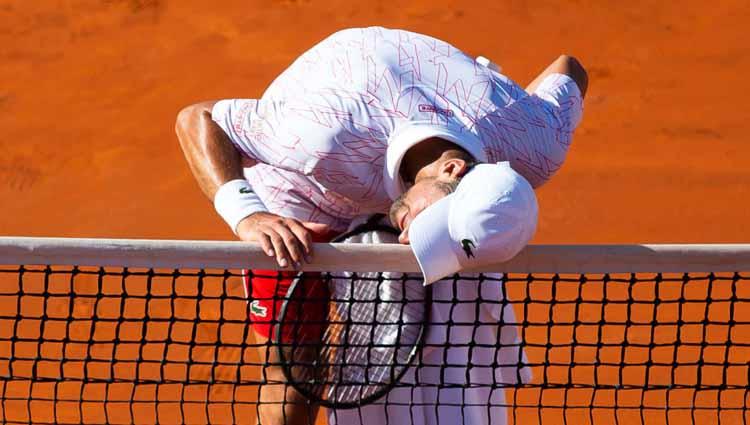 Novak Djokovic menyentuh net saat memenangkan satu game atas Alexander Zverev.