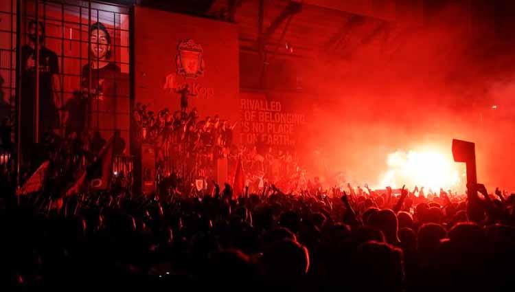 Fans Liverpool merayakan kemenangan di luar Anfield sambil menyalakan flare.