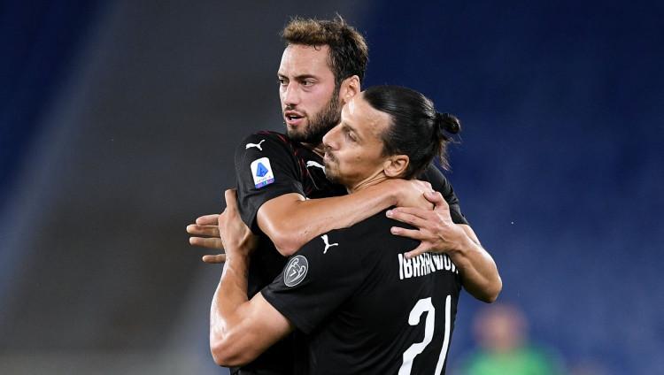 Selebrasi Hakan Calhanoglu dan Zlatan Ibrahimovic dalam laga Lazio vs AC Milan di Liga Italia 2019-20, Minggu (05/07/20). - INDOSPORT