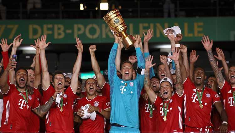 Manuel Neuer (jersey biru) selaku kapten Bayern Munchen mengangkat trofi juara DFB Pokal 2019/20.