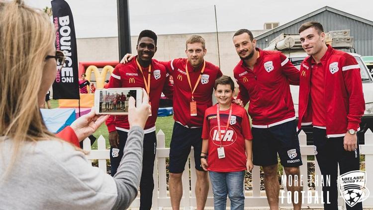 Kiper Adelaide United, Isaac Richards (kedua dari kanan), saat berpose bareng penggemar.
