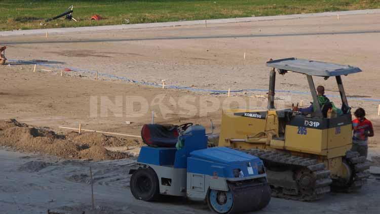 Alat berat terlihat untuk meratakan tanah lapangan di Stadion Gelora 10 November.