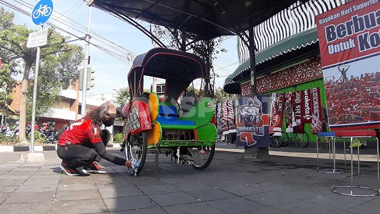 Aksi unik Pasoepati menyambut Hari Suporter Nasional 12 Juli 2020 di Kawasan Ngarsopuro, Solo. bersihkan sejumlah becak. Copyright: Ronald Seger Prabowo/INDOSPORT