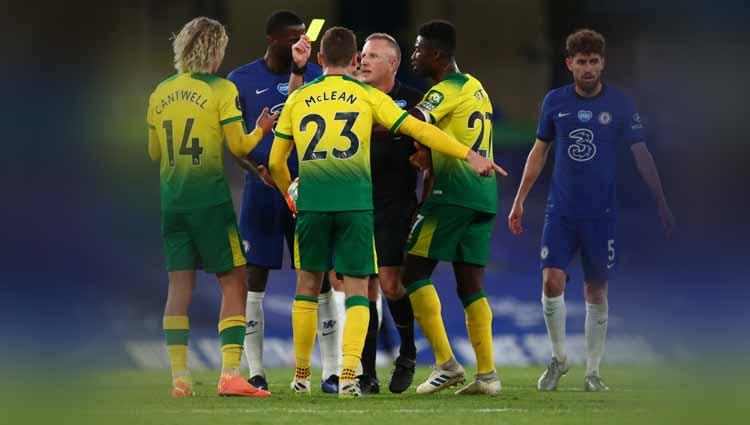 Pemain Norwich City, Todd Cantwell menerima kartu kuning dari wasit Jon Moss saat menjatuhkan pemain Chelsea Mateo Kovacic pada Liga Primer Inggris.
