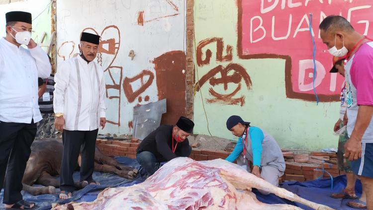 Komisaris PT PBB, Umuh Muchtar (kedua kiri) melihat proses pemotongan sapi saat kurban di kediamannya Jalan Desa, Kiaracondong, Kota Bandung, Jumat (31/07/20).