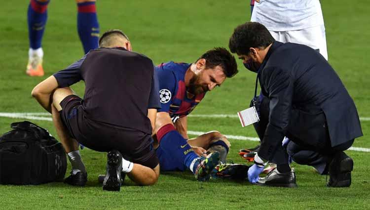 Lionel Messi mendapat pertolongan dari medis setelah mengalami cedera dalam laga Liga Champions Barcelona vs Napoli.