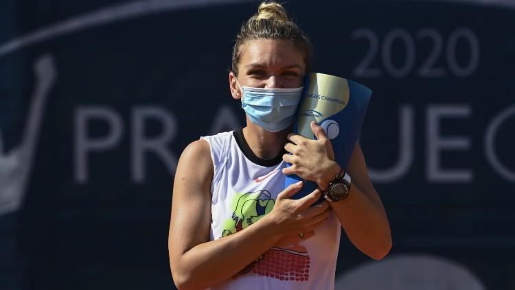 Simona Halep berfoto dengan trofi Praha Terbuka usai mengalahkan Elise Mertens di partai final, Senin (17/08/20).