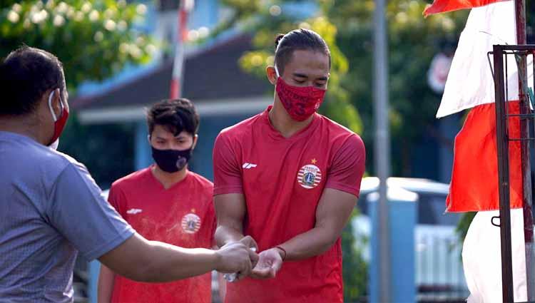 Ryuji Utomo memakai hand sanitizer sebelum memasuki lapangan pada latihan perdana Persija Jakarta di Lapangan PSAU TNI AU, Halim, Rabu (19/08/20). Foto: Khairul Imam/Persija