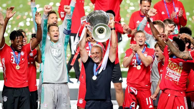 Pelatih Bayern Munchen, Hansi Flick, mengangkat trofi Liga Champions. Copyright: Twitter @fcbayern