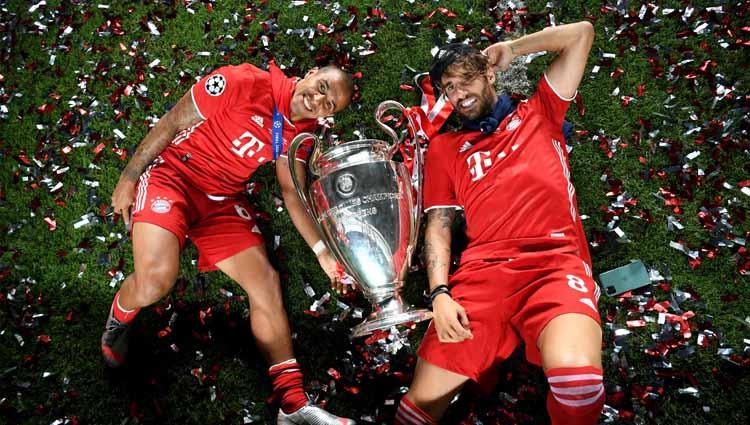 Pemain Bayern Munchen Thiago Alcantara dan Javi Martinez foto bersama trofi Liga Champions.