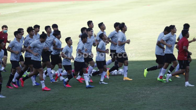 Sebelum memulai materi latihan, para pemain Timnas Indonesia U-19 melakukan pemanasan dengan berlari di sekitaran lapangan Stadion Madya. - INDOSPORT