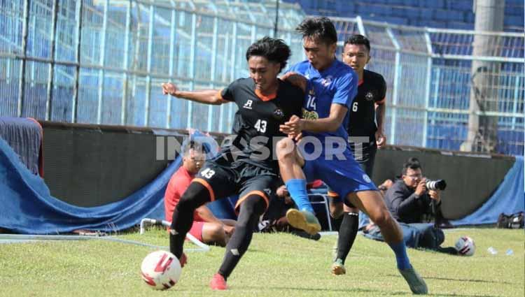Jayus Hariono berebut bola dengan pemain Kaki Mas Dampit dlm uji coba Arema FC