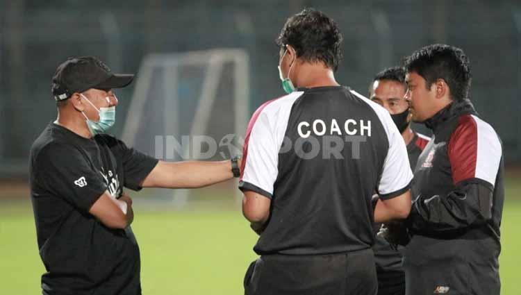 Rahmad Darmawan saat berdiskusi dengan tim pelatih Madura United. - INDOSPORT