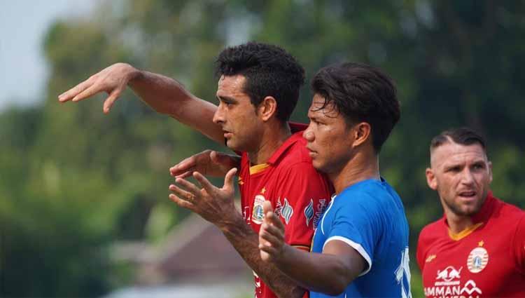 Bek Bhayangkara FC, Achmad Jufriyanto (tengah) menjaga ketat striker Persija, Marko Simic pada uji coba antara Persija vs Bhayangkara, Rabu (22/09/20).