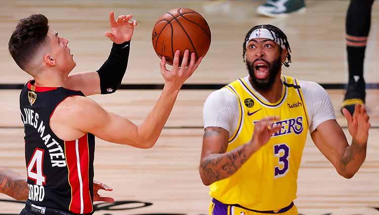 Pemain Miami Heat, Tyler Herro mengarahkan bola ke gawang dan diadang Anthony Davis pemain Los Angeles Lakers di Final NBA. - INDOSPORT