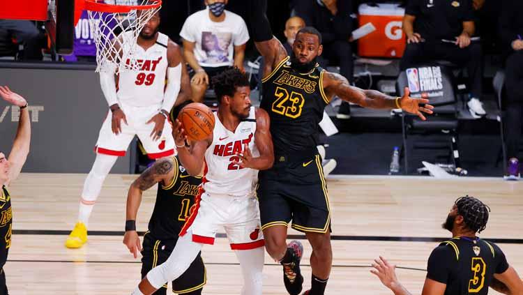 LeBron James berusaha menghalangi Jimmy Butler yang ingin mencetak poin di laga final NBA 2019/20 antara LA Lakers vs Miami Heat.