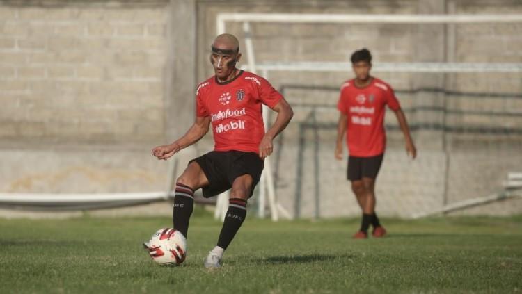 Pemain Bali United M Sidik Saimima menggunakan pelindung wajah dalam sesi latihan.