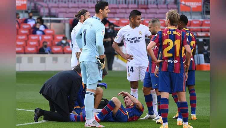 Lionel Messi menerima perawatan medis saat mengalami cedera dalam pertandingan antara Barcelona vs Real Madrid di Camp Nou, Sabtu (24/10/2020).