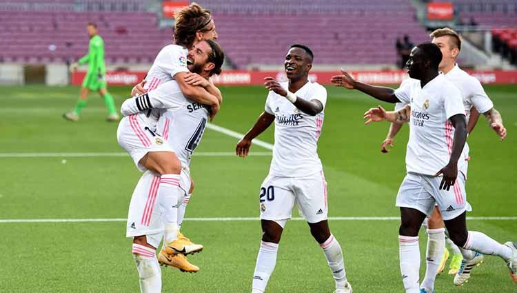 Luka Modric melakukan selebrasi bersama timnya usai mencetak gol ketiga timnya dalam pertandingan antara Barcelona vs Real Madrid di Camp Nou, Sabtu (24/10/2020).