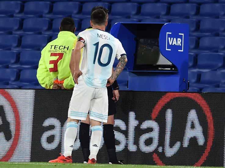 Lionel Messi dan wasit Raphael Claus saat memeriksa VAR. Copyright: Marcelo Endelli/Getty Images