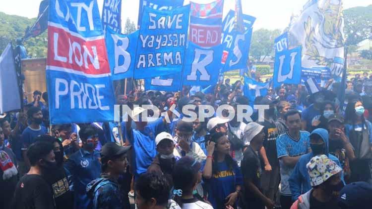Aremania menyuarakan aspirasi menuntut berakhirnya dualisme Arema di depan gedung DPRD Kota Malang.