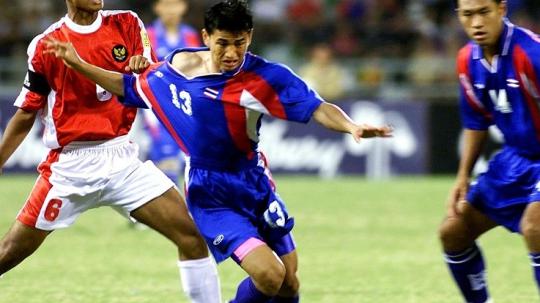 Pemain Thailand, Kiatisuk Senamuang, berupaya melewati bek Indonesia, Eko Purdjianto, dalam pertandingan Piala AFF, 18 November 2000.