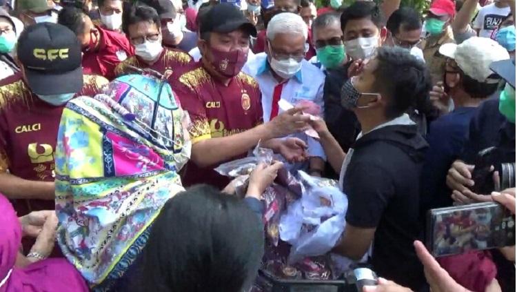 Gubernur Sumsel, Herman Deru, menerima uang pembayaran dari pembeli jersey Sriwijaya FC di Kambang Iwak, Palembang.