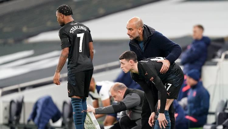 Pelatih Manchester City, Pep Guardiola, dan dua pemainnya, Raheem Sterling dan Phil Foden, saat melawan Tottenham Hotspur dalam pertandingan Liga Inggris, Minggu (22/11/20) dini hari WIB. Copyright: Matt McNulty/Manchester City FC via Getty Images